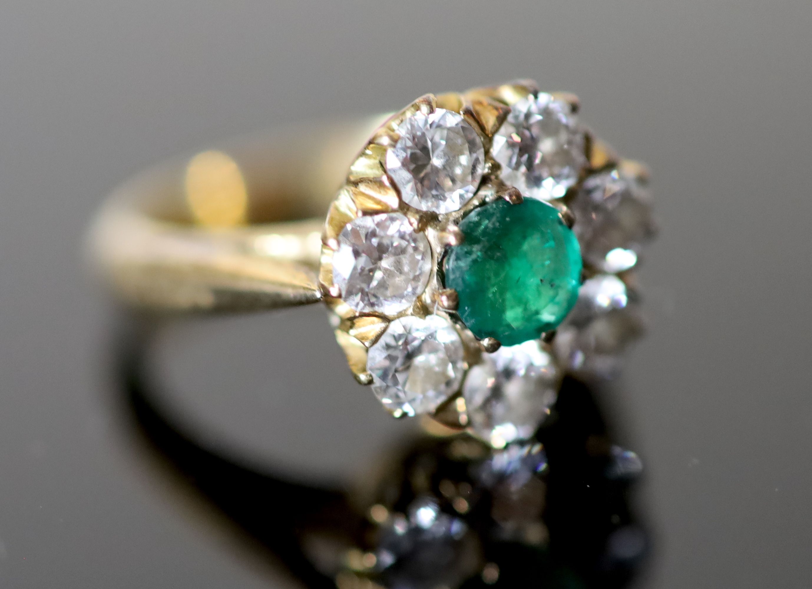 A 20th century gold, emerald and diamond set circular eight stone cluster ring,